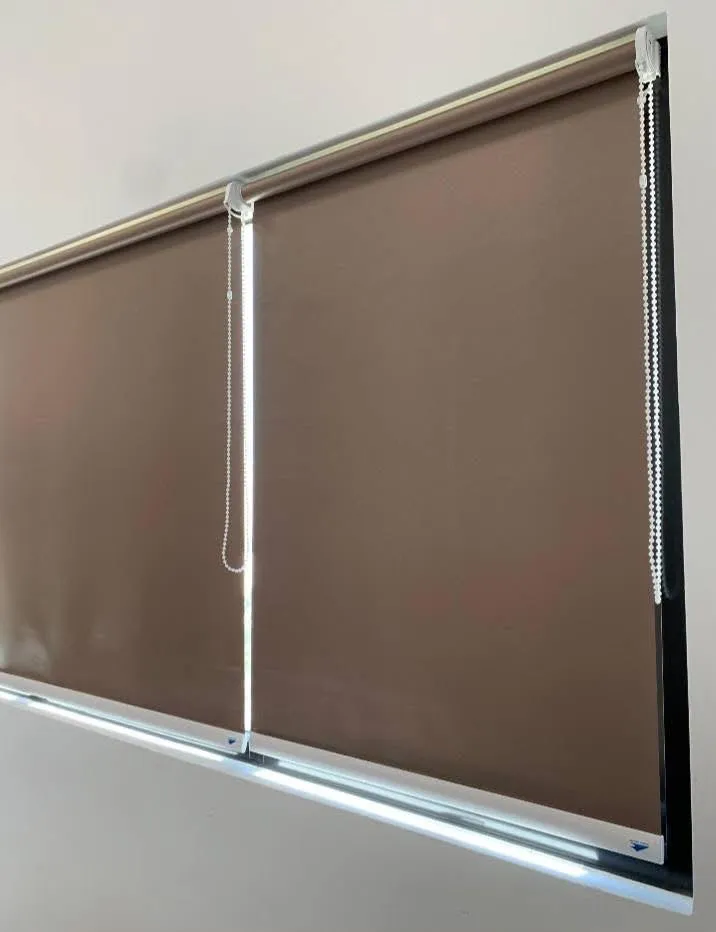 Roller blinds warna cokelat hangat dua lajur dengan rantai tarikan samping yang rapi