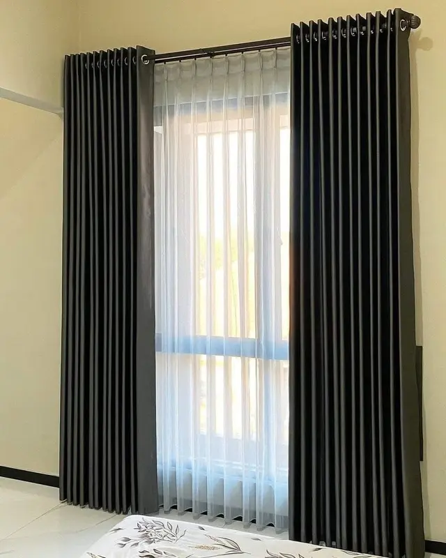 Gorden blackout warna hitam arang (charcoal) berpadu vitrase putih di kamar tidur utama