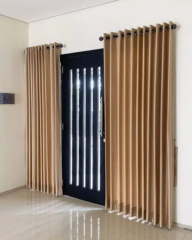 Gorden smokring minimalis warna cokelat keemasan pada pintu kaca berbingkai hitam